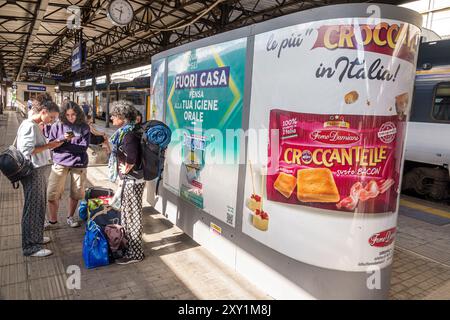 Livourne Italie, Piazza Dante, gare centrale de train Livourne, passagers de plate-forme femmes en attente, kiosque de panneaux publicitaires, Forno Damiani Banque D'Images