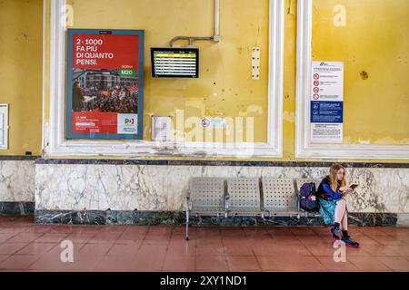 Livourne Italie, Piazza Dante, gare centrale de Livourne, banc de zone d'attente, femme résidant seule, livre de lecture, intérieur, italien Banque D'Images