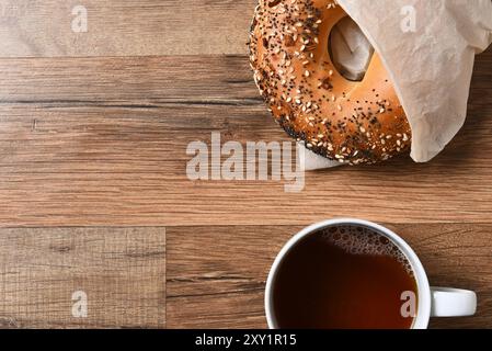 Bagel frais et tasse de café chaud sur une table en bois rustique avec espace de copie. Banque D'Images