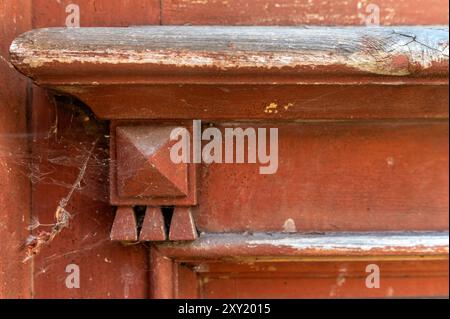 Le détail complexe d'angle d'une porte en bois altérée montre l'usure et les toiles d'araignée, suggérant l'âge. Banque D'Images