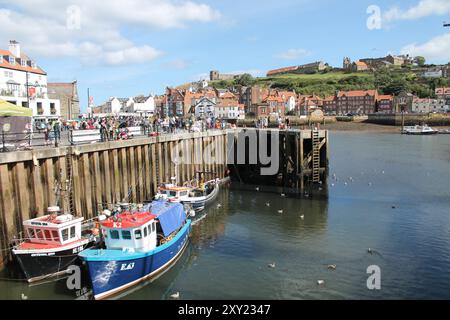 Whitby North Yorkshire Royaume-Uni 21 août 21 2024 Whitby une ville balnéaire britannique avec des bateaux amarrés dans le port sur un été chaud Banque D'Images