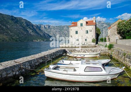 Village de Stoliv avec vue sur la baie de Kotor et bateaux de pêche en premier plan, baie de Kotor, Monténégro Banque D'Images