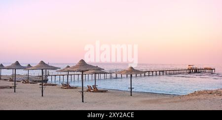 Photo d'une plage vide à un coucher de soleil violet. Banque D'Images