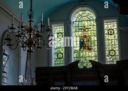 Les vitraux élégants représentent des scènes bibliques vives, projetant une lumière colorée dans la paisible église de St Marys à Avington, Hampshire, Royaume-Uni Banque D'Images