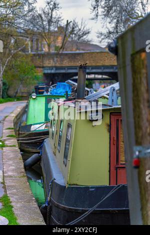 Des bateaux étroits colorés et des péniches étroites amarrés et amarrés sur la rivière dans le quartier résidentiel de Maida Vale, avec beaucoup de jonque sur leur toit. Banque D'Images