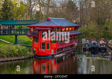 Grand bateau rouge transformé en restaurant chinois flottant dans le quartier résidentiel de Regents Park à Maida Vale à Londres avec des bateaux étroits amarrés sur le Banque D'Images