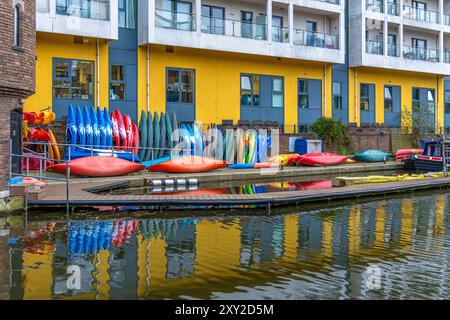 Kayaks de sports de loisirs colorés sur un quai devant un bâtiment dans le quartier résidentiel de Maida Vale à Londres sur le Regent's canal avec th Banque D'Images