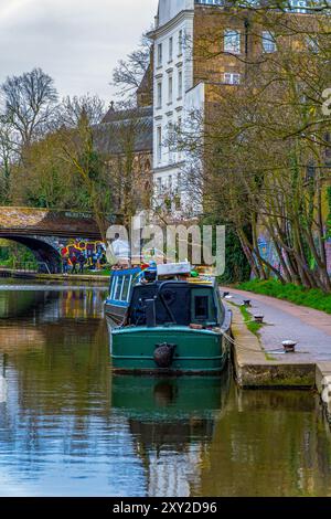 Des péniches en bois accostées et amarrées dans le quartier résidentiel de Maida Vale et un abri pour sans-abri sous un pont. Banque D'Images