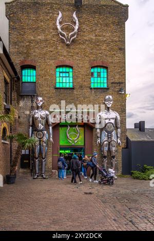 Façade du légendaire magasin de vêtements cyber et de danse Cyberdog avec deux robots métalliques géants à l'entrée du marché de Camden. Londres. Banque D'Images