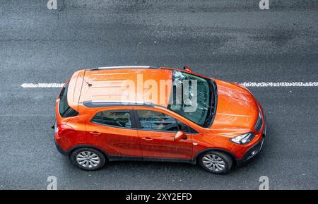 OSTRAVA, RÉPUBLIQUE TCHÈQUE - 12 JUILLET 2024 : Orange Opel Mokka Un parking croisé sur la rue, vue de dessus Banque D'Images