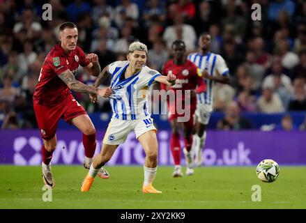 Toby Mullarkey de Crawley Town (à gauche) et Julio Enciso de Brighton & Hove Albion se battent pour le ballon lors du match de deuxième tour de la Carabao Cup à l'American Express Stadium de Brighton. Date de la photo : mardi 27 août 2024. Banque D'Images