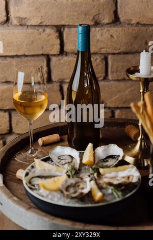 Huîtres élégantes sur glace avec citron et vin blanc, parfaites pour les repas gastronomiques et les occasions spéciales Banque D'Images