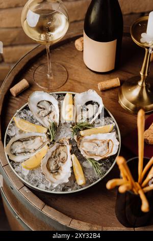 Huîtres élégantes sur glace avec citron et vin blanc, parfaites pour les repas gastronomiques et les occasions spéciales Banque D'Images