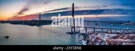 En hiver, vue panoramique sur le coucher du soleil sur le célèbre pont de passage par câble de Vladivostok à l'île de Russky, à l'extrême-Orient de la Russie Banque D'Images