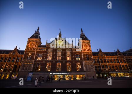 La gare centrale illuminée au crépuscule - Amsterdam, pays-Bas Banque D'Images