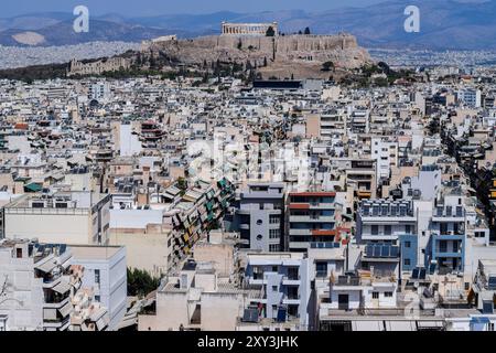 Athènes, Grèce. 26 août 2024. Le paysage urbain du centre de la capitale grecque peut être vu avec Acropole en arrière-plan. Le pays est confronté à une pénurie croissante de logements qui est devenue un grave problème social le rendant extrêmement inabordable pour les ménages ordinaires. Alors que le gouvernement grec blâme le programme Golden Visa et a des plans pour resserrer les règles, beaucoup de gens blâment également les locations à court terme comme Airbnb. Crédit : Dimitris Aspiotis/Alamy Banque D'Images