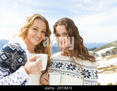 Deux happy female friends enjoying boisson chaude dans un café au ski resort Banque D'Images