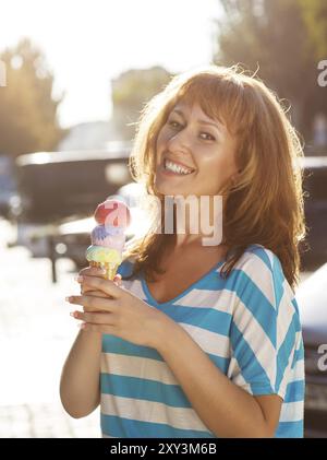 Femme frappante tenant un cône de crème glacée dans ses mains à l'extérieur Banque D'Images