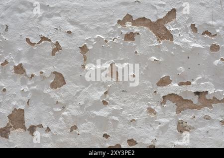 La texture ou le fond des murs du bâtiment sont peints en blanc, vieux et endommagés. Banque D'Images