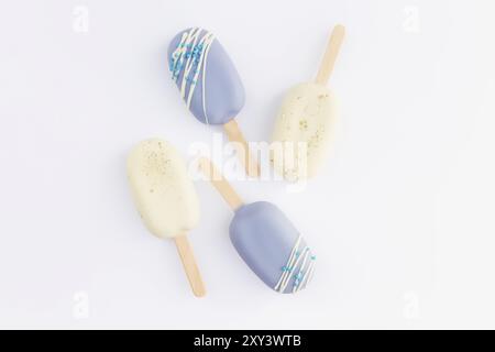 Glaces de biscuit bleu et blanc sur un bâton sur fond blanc. Banque D'Images