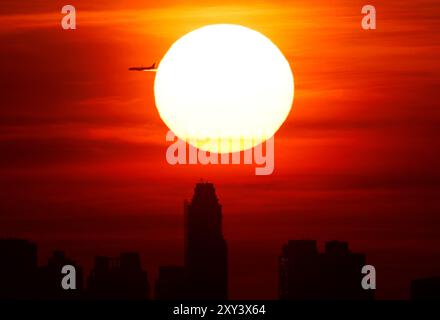 Flushing Meadow, États-Unis. 27 août 2024. Le soleil se couche derrière les gratte-ciel de Manhattan depuis le sommet du stade Arthur Ashe lors de la première manche des US Open Tennis Championships 2024 au USTA Billie Jean King National Tennis Center le mardi 27 août 2024 à New York. Photo de John Angelillo/UPI crédit : UPI/Alamy Live News Banque D'Images