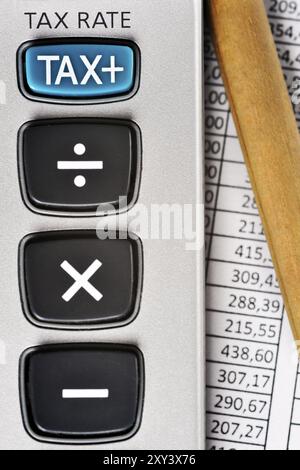 Détail de la calculatrice, en mettant l'accent sur la clé FISCALE, à côté d'une feuille de papier avec des chiffres et un crayon Banque D'Images