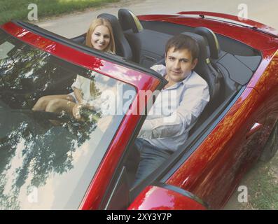 Heureux couple red cabriolet dans une journée ensoleillée Banque D'Images