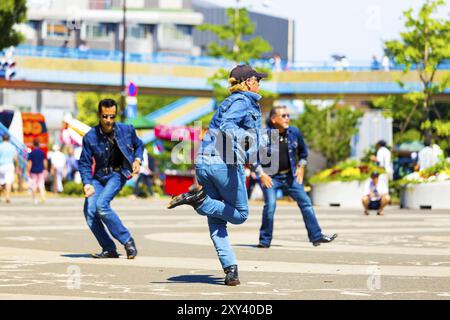 TOKYO, JAPON, 26 JUIN 2016 : gang de danseurs de rockabilly vêtus d'une tenue en jean vintage avec des coiffures tranchées en dos faisant la touche un jour ensoleillé Banque D'Images