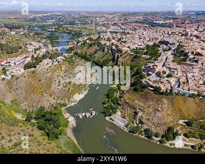 Vue panoramique d'une ville avec des maisons sur des collines traversées par une rivière, avec un pont en arrière-plan, vue aérienne, Tolède, Tage, Castille-la Manche Banque D'Images