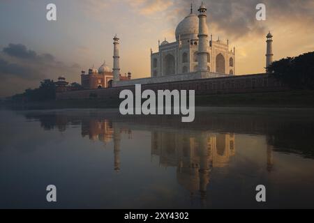 Le Taj Mahal brille brillamment d'un coucher de soleil coloré vu de la rivière sainte Jamuna Banque D'Images