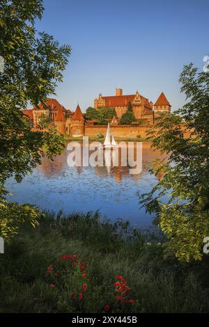 Château de Malbork au coucher du soleil en Pologne, vue sur la rivière Nogat, monastère fortifié de l'ordre des chevaliers teutoniques, datant du 13ème siècle Banque D'Images