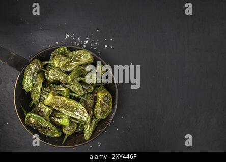 Partie de Pimientos de Padron sur une dalle d'ardoise rustique, portrait, close-up shot Banque D'Images