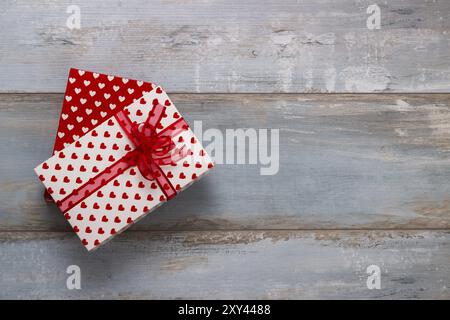 Coffrets cadeaux enveloppés dans du papier polkadots avec des rubans sur fond de bois, style rétro vintage Banque D'Images