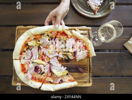 Woman eating pizza et boire le vin blanc en restaurant en plein air. Vue d'en haut Banque D'Images