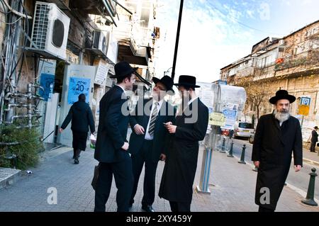 Hommes juifs haredi socialisant dans le quartier ultra-orthodoxe de Geula à Jérusalem, Israël. Banque D'Images