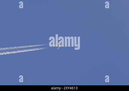 Boeing 787-8 Dreamliner survolant un ciel bleu avec une traînée de vapeur ou une traînée derrière, Angleterre, Royaume-Uni, Europe Banque D'Images