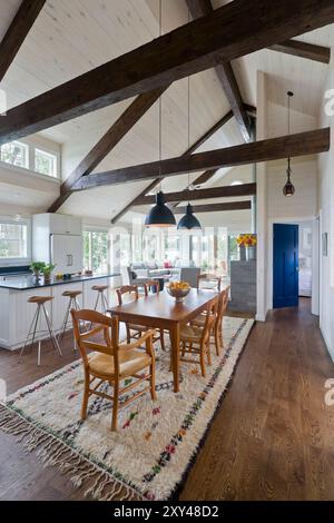 Chalet moderne salle à manger avec poutres en bois sombre et vue sur la cuisine et le salon Banque D'Images