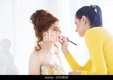 Make-up artist faire compenser young beautiful bride appliquant le maquillage mariage Banque D'Images