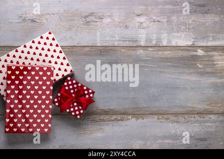 Coffrets cadeaux enveloppés dans du papier polkadots avec des rubans sur fond de bois, style rétro vintage Banque D'Images