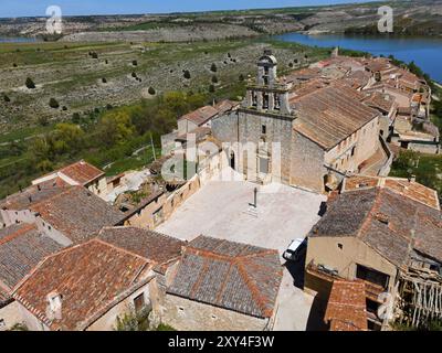 Une grande église domine un village entouré de maisons et d'éléments naturels, vue aérienne, Maderuelo, Rio Riaza, rivière Riaza, Embalse de Lina Banque D'Images