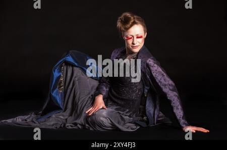 Portrait d'une jolie femme avec une coiffure sévère et une longue robe sombre Banque D'Images