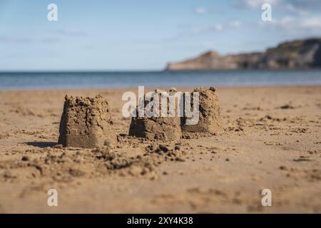 Châteaux de sable sur la plage de Runswick Sands, North Yorkshire Angleterre, Royaume-Uni, avec Kettleness en arrière-plan Banque D'Images