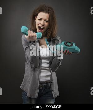 Portrait de l'adolescente drôle avec vieux téléphone Banque D'Images