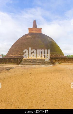 Premier plan de champ de terre menant aux marches des ruines d'Abhayagiri Stupa lors d'une belle journée de ciel bleu dans l'ancienne capitale du Royaume d'Anuradhapura au Sri Lanka. Banque D'Images