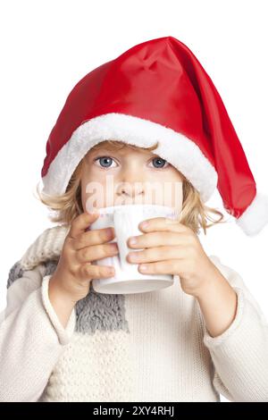 Enfant en chapeau de Père Noël buvant du chocolat chaud. Concept de Noël, isolé sur fond blanc Banque D'Images