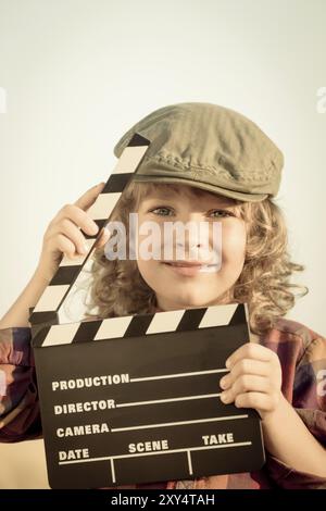 Kid holding clapper board dans les mains. Cinema concept. Retro style Banque D'Images