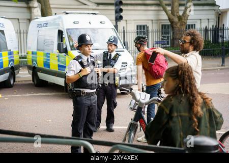 Londres, Royaume-Uni, 18 juillet 2024. Les policiers aident les gens avec des vélos Banque D'Images