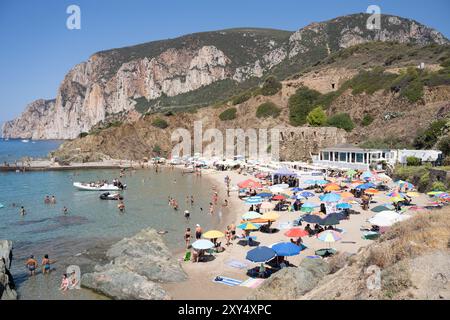 Masua, Italie - 23 août 2023 : plage de Masua dans le sud de l'île de Sardaigne, Italie, avec les restes d'un vieil entrepôt utilisé lors de l'abandon de Masua Banque D'Images