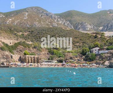 Masua, Italie - 23 août 2023 : plage de Masua communément appelée il Molo, avec les restes d'un ancien entrepôt utilisé lorsque la mine de Masua était encore en exploitation Banque D'Images