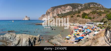 Masua, Italie - 23 août 2023 : vue panoramique sur la plage de Masua au sud de l'île de Sardaigne, Italie, avec les restes d'un ancien entrepôt utilisé dans le Banque D'Images